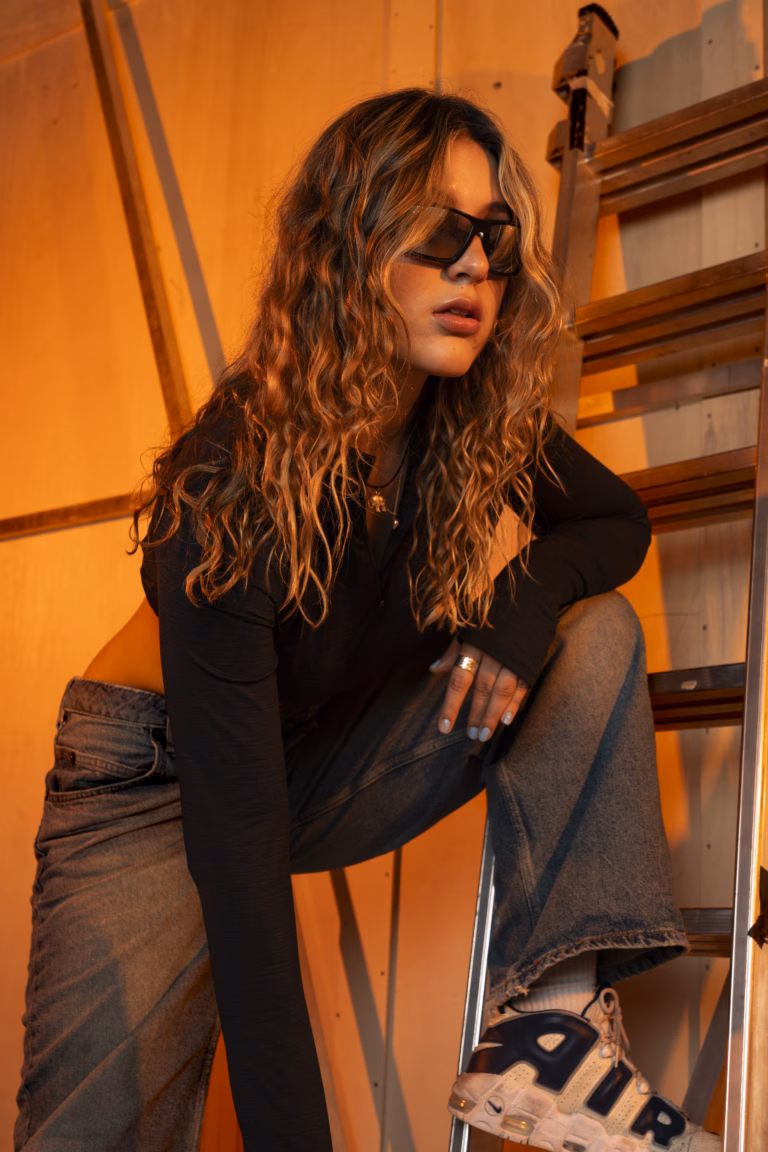 Editorial shoot by Yune: Eva Mavis poses for university work with sunglasses and red ambient light.